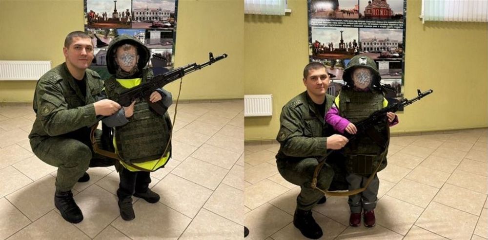 Ребенок стоит с оружием рядом с военным в 72 ОУЦ Борисова