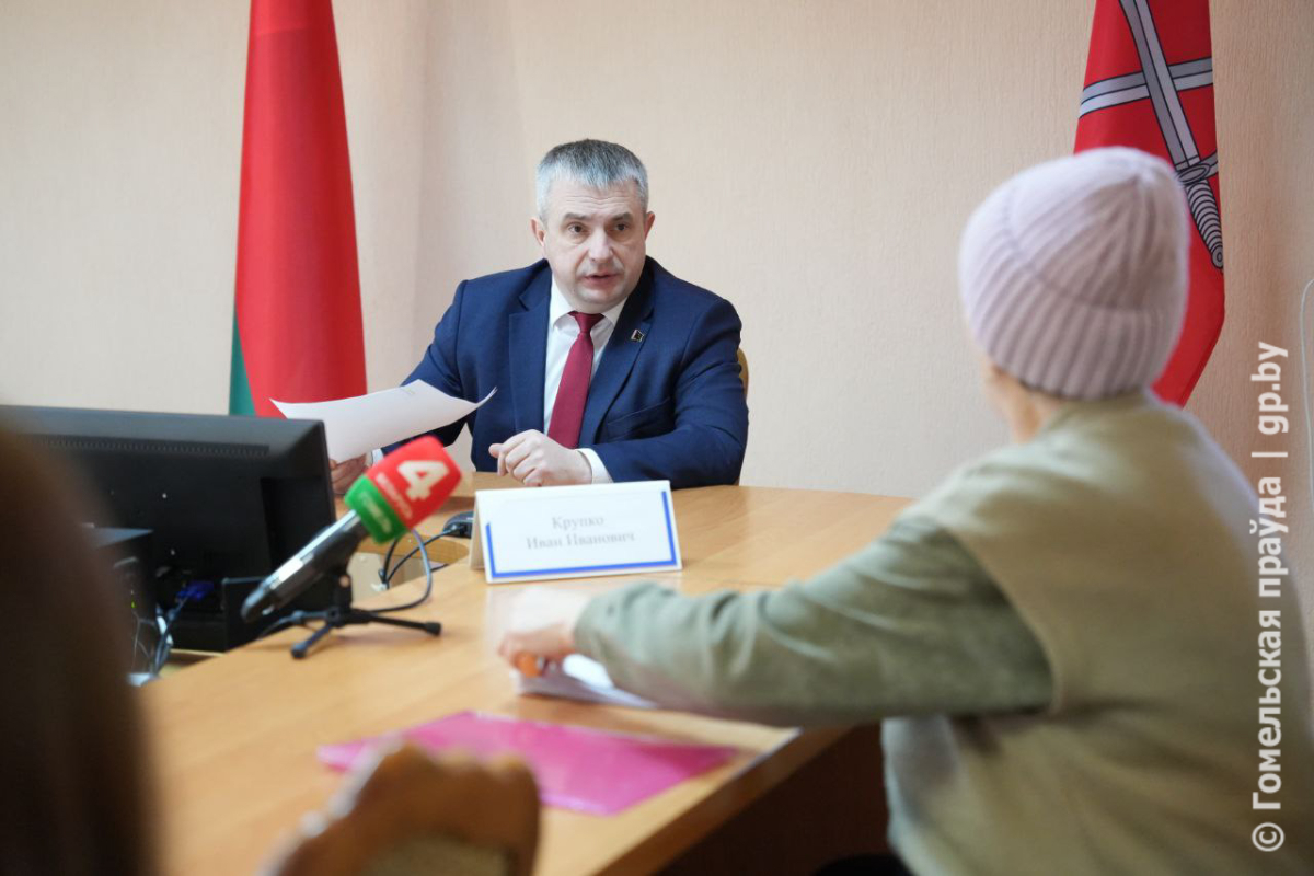 чиновник в синем костюме сидит за столом 